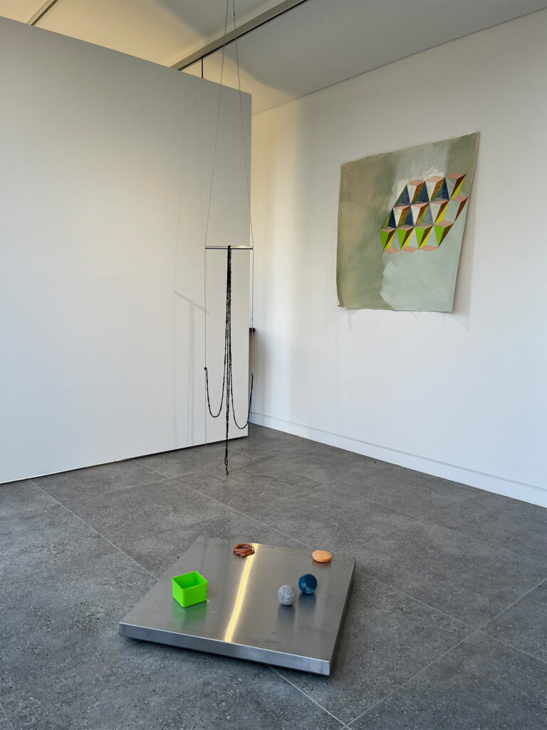 Material Exchange installation view Fiona Morgan and Kate Stewart 2025, acrylic painting on canvas, Kate Stewart trapeze installation, wool, steel pipe, curtain chain, fiona Morgan floor work, stainless steel table top, found plastic objects